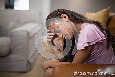 Side view of tired girl sitting on sofa Stock Photo