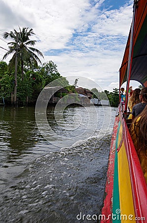 Side view from a tourist long boat with young people in Bangkok, Thailand Stock Photo