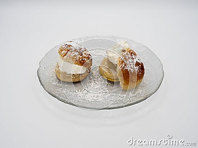 Side view of traditional Swedish semla, or fastlagsbulle, with whipped cream, almond paste and confectioners' sugar. Stock Photo