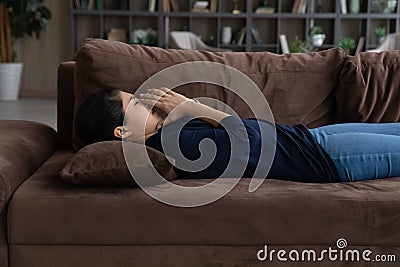 Side view unhappy Indian woman lying on couch alone Stock Photo