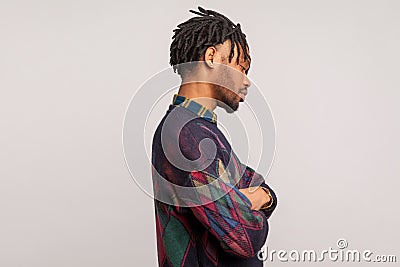 Side view of upset depressed african guy with dreadlocks lonely standing, crossing arms on chest, break up, family conflict Stock Photo