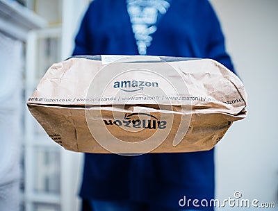 Side view of woman holding new design for the Amazon Prime package parcel with Editorial Stock Photo