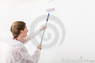 Side view of woman painting with anchor roller Stock Photo