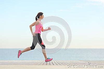 Side view of a woman running on the beach Stock Photo