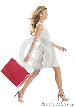 Side View Of Woman Walking With Shopping Bag Stock Photo