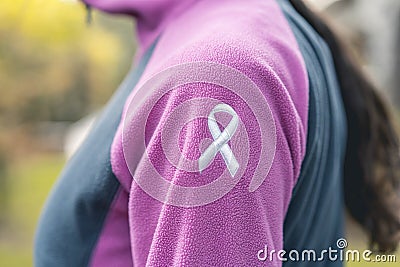 Side view of a woman wearing a sweatshirt with an embroidered cancer awarness ribbon Stock Photo