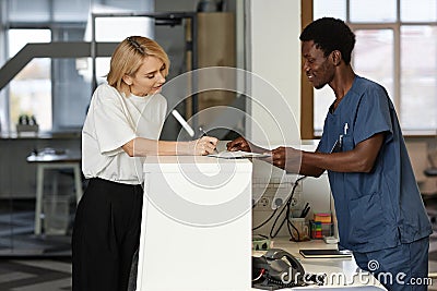 Side view of young African American male clinician helping female client Stock Photo