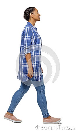 Side view of a young black girl walking in jeans and a checkered shirt Stock Photo