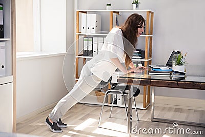 Young Businesswoman Doing Push Up Stock Photo