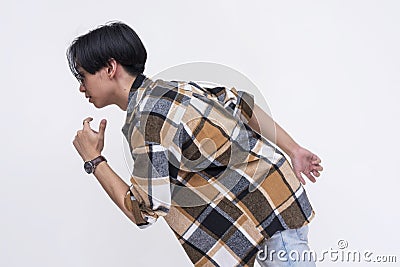 Side view of a young chinese man makes a getaway in an exaggerated way. Active dynamic teenager in motion. Stock Photo