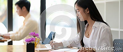 Side view of young college student concentrating on her assignment Stock Photo