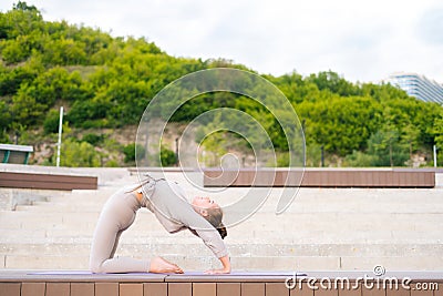 Side view of young gymnast woman performs enjoying bending body backward exercises, various gymnastic and yoga exercises Stock Photo