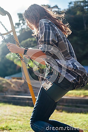 Side view of young happy girl on swing Stock Photo