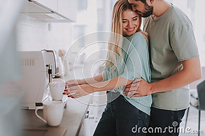 Happy lovers making coffee in bright kitchen Stock Photo