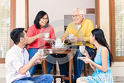 Young man and woman visiting parents at home in the afternoon Stock Photo