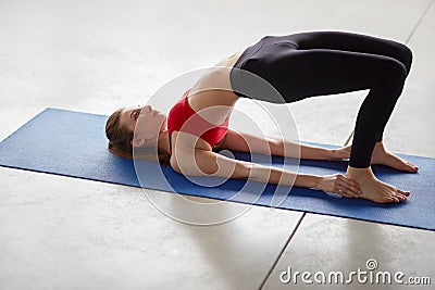 Side view of young woman doing half bridge pose Stock Photo