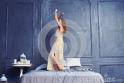 Side view of a young woman in a long nightgown dancing on the be Stock Photo