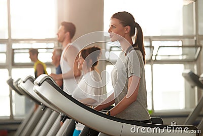 Side view young woman on treadmill at gym. Stock Photo