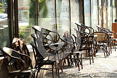Sidewalk cafe early morning chairs windows Stock Photo