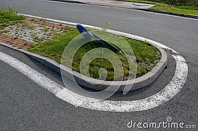 Sidewalk of concrete cubes at a crossing overgrown with weed flowers. neighborhood without regular maintenance. sidewalks difficul Stock Photo