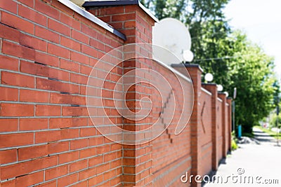 A sidewalk paved along a brick fence Stock Photo