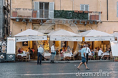 Sidewalk restaurant with tourists in Roman square a sunny summer Editorial Stock Photo