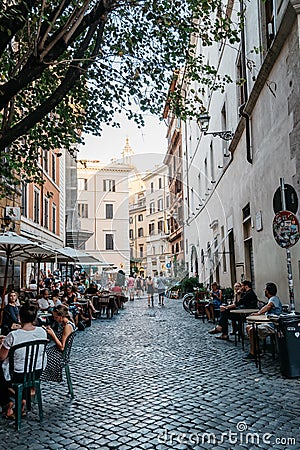 Sidewalk restaurant with tourists in Roman street a sunny summer Editorial Stock Photo