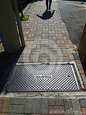 Sidewalk with telephone manhole Stock Photo