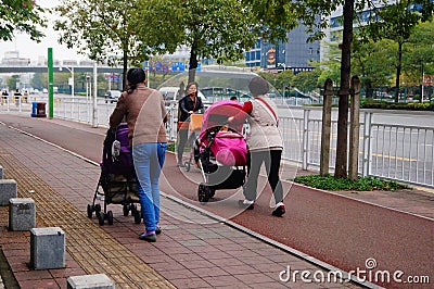 Sidewalk, women pushing baby carriages Editorial Stock Photo