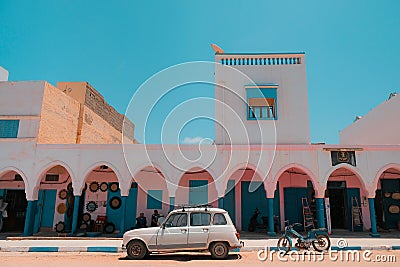 Sidi Ifni, Morocco - colorful market exterior with blue doors and windows, pink walls, white arches. Editorial Stock Photo