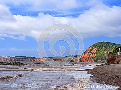 Sidmouth Beach, Devon, England. View towards Ladram Bay, red cliffs in late summer sun. On the Jurassic Coast. Stock Photo
