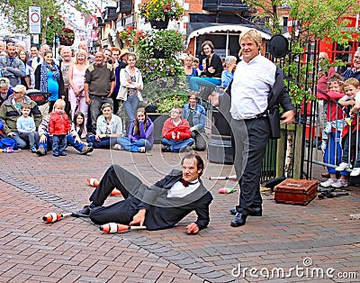 SIDMOUTH, DEVON, ENGLAND - AUGUST 5TH 2012: Two street jugglers and entertainers perform in the town square to an appreciative Editorial Stock Photo