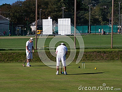 SIDMOUTH, DEVON, ENGLAND - SEPTEMBER 20,2019: Two elderly gentlemen enjoying a game of croquet in the late summer sun. Editorial Stock Photo