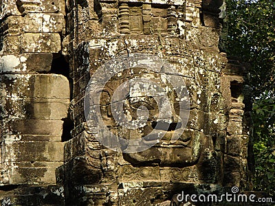 Face sculpted in stone in the Khmer temple complex of Angkor Stock Photo