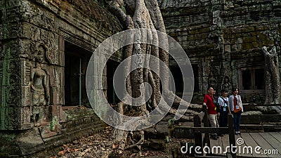 Siem Reap, Cambodia - December, 30, 2019 : Family takes photo at famous tree Ta Prohm Temple Editorial Stock Photo