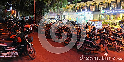 Parking with lots of motorbikes on a night Cambodian street. Popular Asian transport Editorial Stock Photo