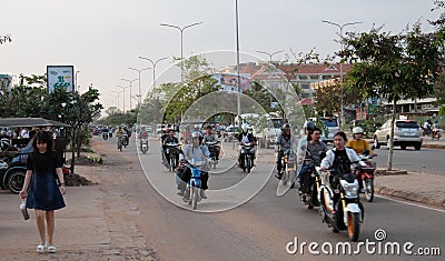 People on mopeds ride on a city street. Typical traffic in an Asian city. City life Editorial Stock Photo