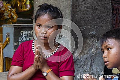 Siem Reap, Cambodia - 22 March 2018: Ethnic tourist in Angkor Wat temple, Cambodia. Praying cambodian children Editorial Stock Photo