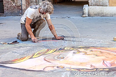 Siena, Italy - August 18, 2013: Street artist painting on asphalt chalk portrait of a girl. . Street art. Editorial Stock Photo