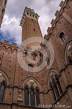 Siena Tower - Looking up towards Torre del Mangia Mangia tower from inside of Palazzo Publico inner courtyard in Siena, Tuscany Editorial Stock Photo