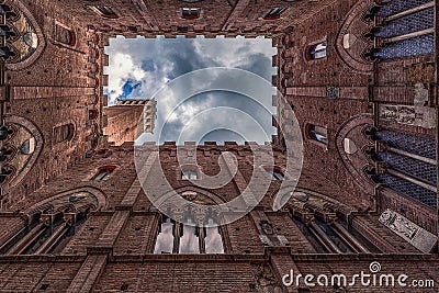 Siena Tower - Looking up towards Torre del Mangia Mangia tower from inside of Palazzo Publico inner courtyard in Siena, Tuscany Editorial Stock Photo