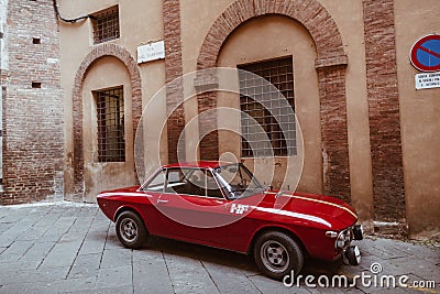 Red vintage car on the street of Siena city Editorial Stock Photo