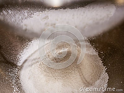 Sieving baking soda powder into a bowl. Stock Photo