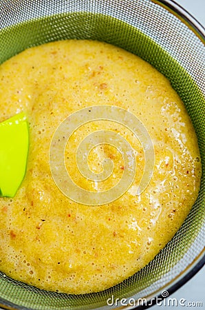 Sieving peaches puree Stock Photo