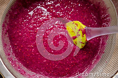 Sieving raspberry puree Stock Photo