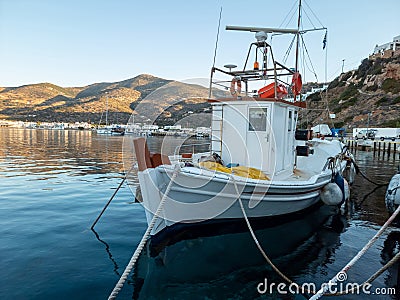 Sifnos island, Platis Gialos, Cyclades Greece. White fishing boat moored at dock Stock Photo