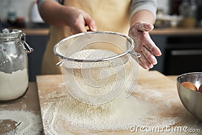 Close up of sifting flour in domestic kitchen Stock Photo