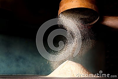 Sifting flour from old sieve. Stock Photo