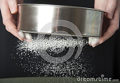 Sifting flour through a sieve closeup Stock Photo