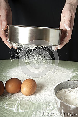 Sifting flour through a sieve Stock Photo